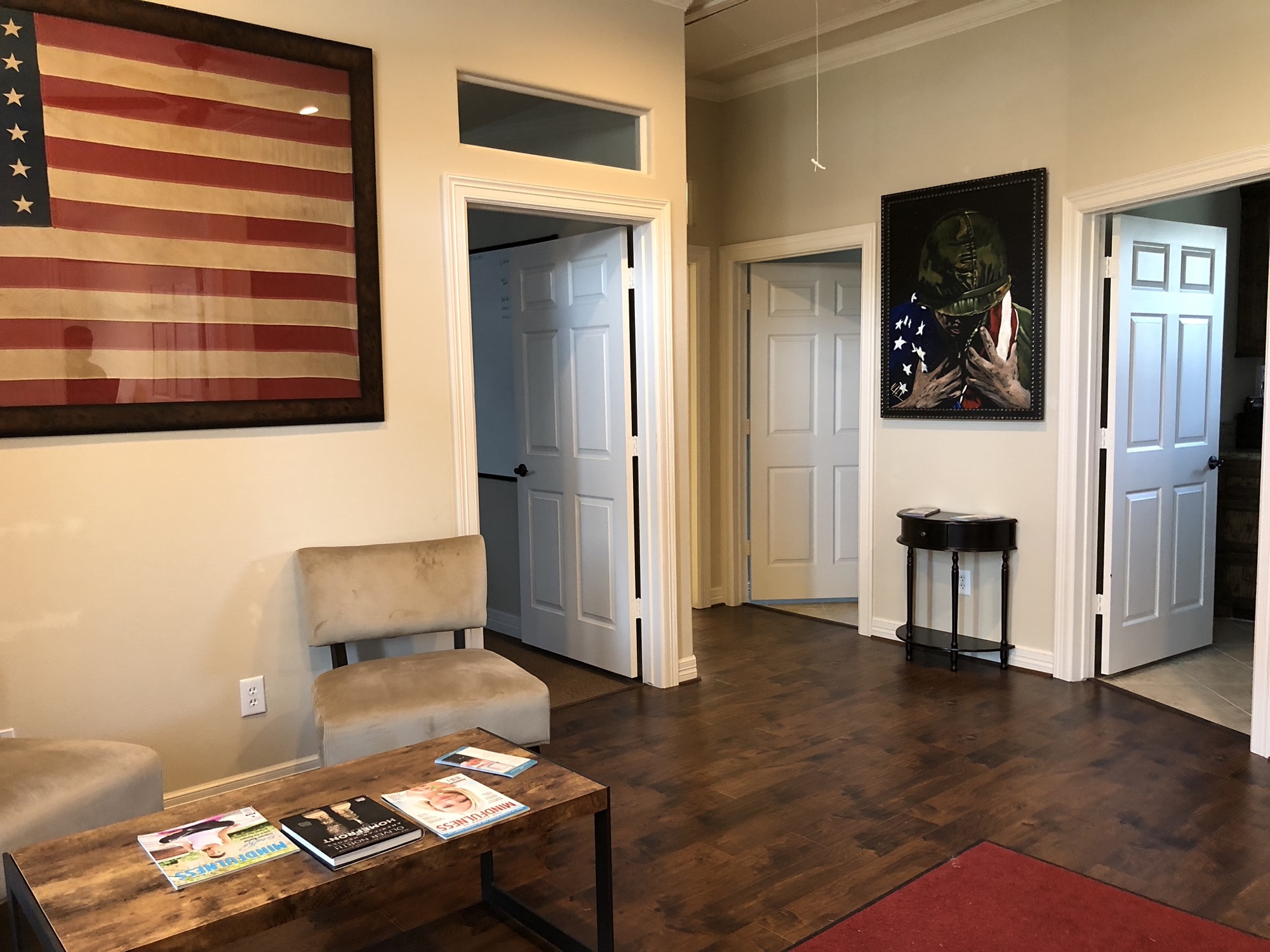 Office waiting room with hardwood floors and framed artwork at Pin Oak Park